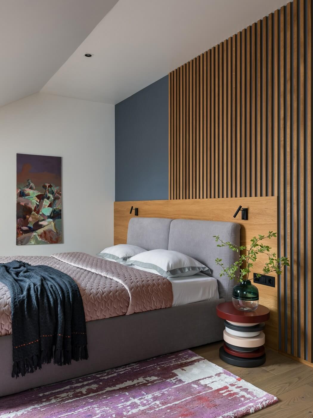 Серо-бирюзовая акцентная стена в изголовье кровати в сочетании с деревянными рейками